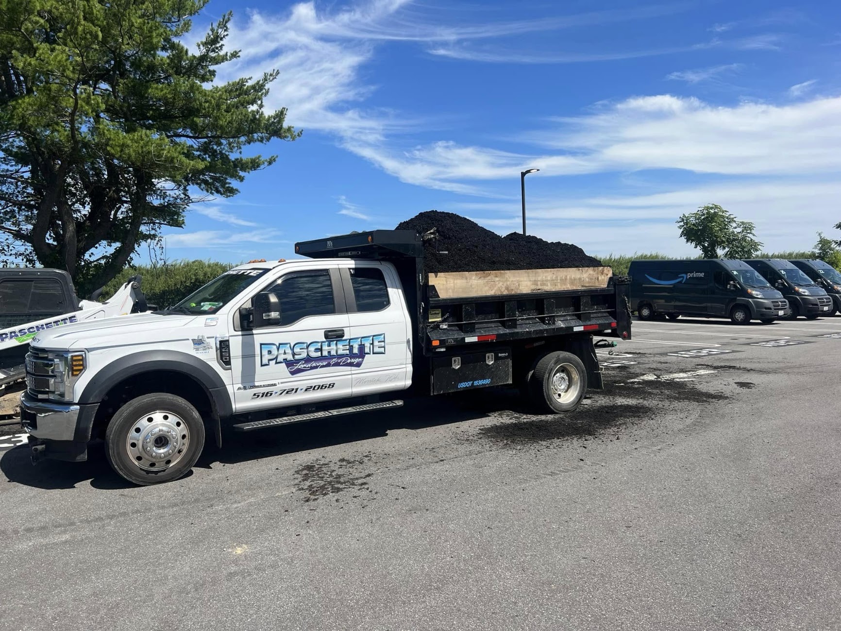 Branded Paschette Landscape & Design dump truck loaded with mulch on a Long Island jobsite