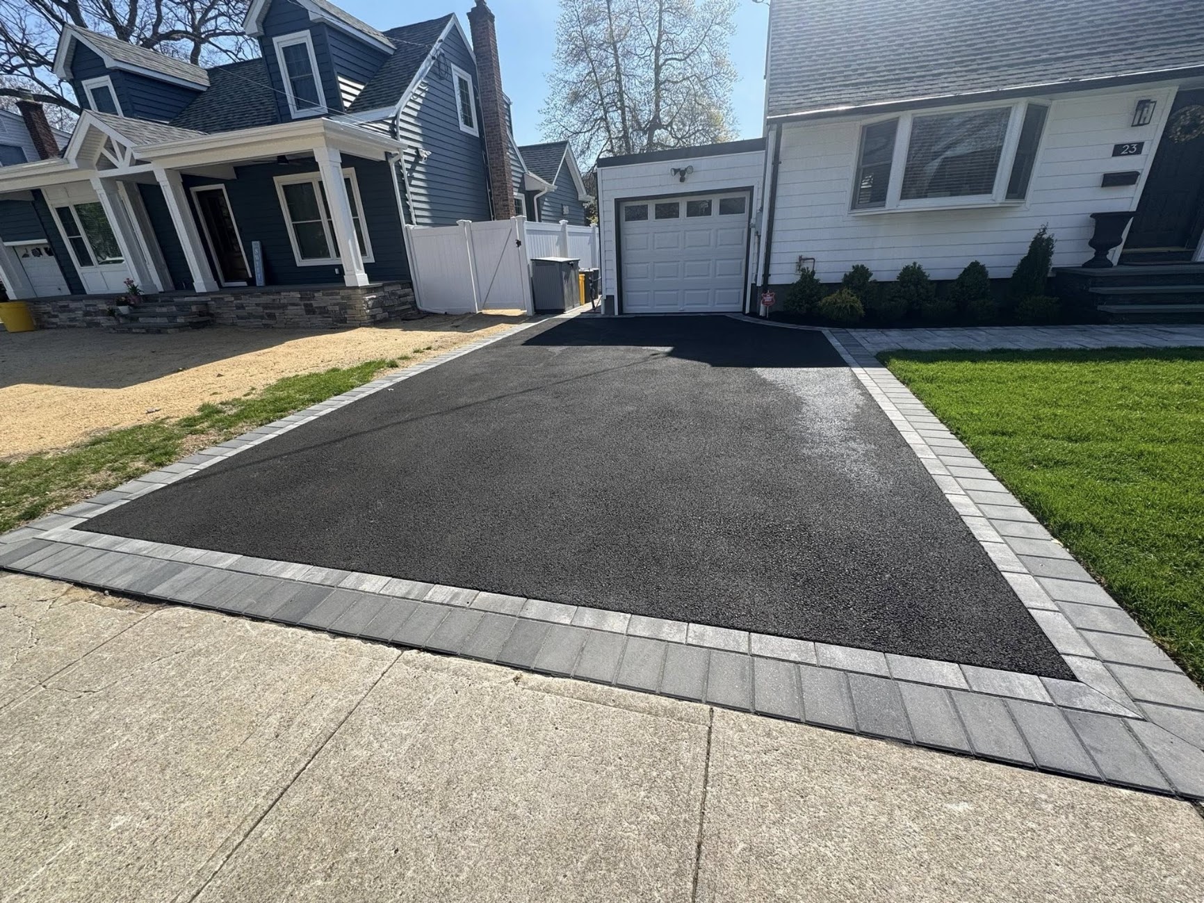 Paschette-installed asphalt driveway with charcoal paver border on a Merrick, NY home